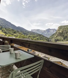 Balcon spacieux pour se détendre face aux montagnes Prakka High Camp à louer à Les Houches – balcon ensoleillé avec table extérieure et vue dégagée sur la chaîne des Fiz.