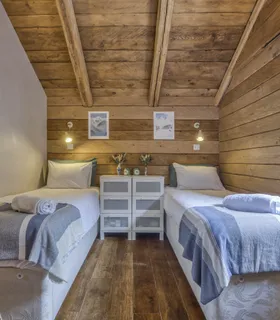 Espace nuit confortable pour enfants ou adolescents Appartement Prakka High Camp à louer à Chamonix – chambre avec deux lits simples, idéale pour des vacances en famille aux Houches.