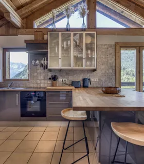 Cuisine ouverte conviviale avec mange-debout et vue montagne Cuisine américaine du Prakka High Camp à louer à Les Houches – appartement moderne avec mange-debout et équipements haut de gamme près de Chamonix Mont Blanc.