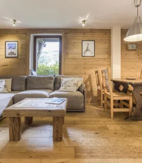 Un salon ouvert sur la nature et les montagnes de Chamonix Appartement à louer à Les Houches – salon du Prakka Base Camp avec vue dégagée sur les Alpes et l’Aiguille Du Midi.