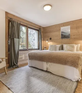 Grande chambre avec lit double confortable et ambiance cosy Chambre parentale avec lit double au Prakka Base Camp – appartement à louer à Les Houches près de Chamonix Mont Blanc, ambiance cosy et décor alpine.
