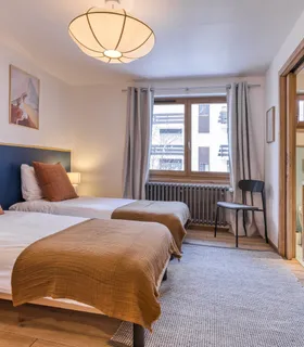 Chambre twin moderne Chambre twin avec salle de douche moderne et WC – vue Alpes.