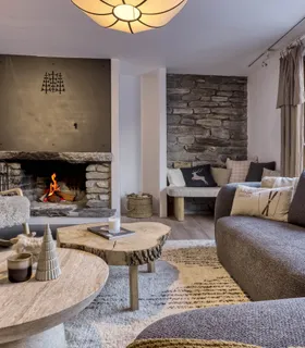 Salon avec cheminée Salon alpin du Chalet Pan Bena avec grande cheminée et canapés.