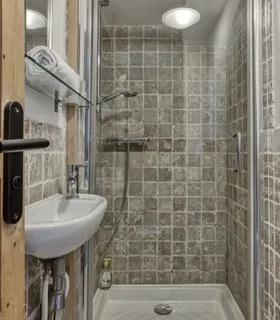Salle d’eau commune avec douche spacieuse et finitions élégantes Salle d’eau partagée moderne du Prakka High Camp à Les Houches – douche à l’italienne, vasque design et équipements soignés dans un appartement à louer à Chamonix.