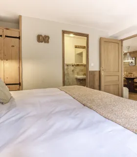 Ambiance chalet avec mobilier en bois et atmosphère cocooning Chambre parentale en bois au Prakka Base Camp – appartement de style chalet alpin à louer à Les Houches, Chamonix.