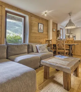 Espace séjour chaleureux avec canapé confortable et décoration alpine Salon du Prakka Base Camp à louer à Les Houches – appartement de vacances cosy avec canapé et ambiance alpine proche de Chamonix Mont Blanc.