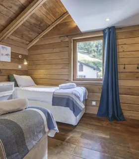 Chambre cosy en bois avec 2 lits simples et rangements intégrés Location à Les Houches – chambre calme avec deux lits simples dans l’appartement Prakka High Camp, proche des pistes de ski et sentiers de randonnée à Chamonix.